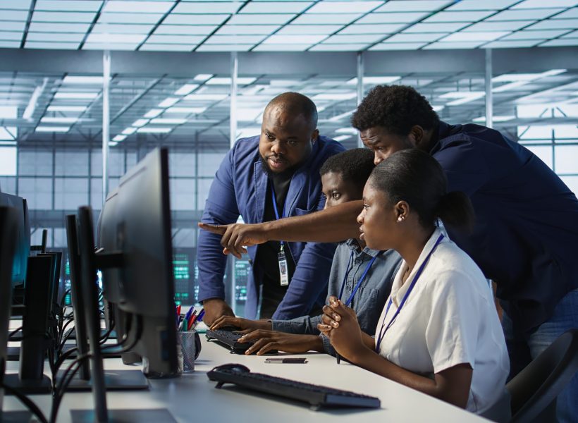 Teamworking engineers talking in server room, developing disaster recovery plans ensuring minimal downtime. Team of data center employees doing brainstorming, monitoring performance, camera A